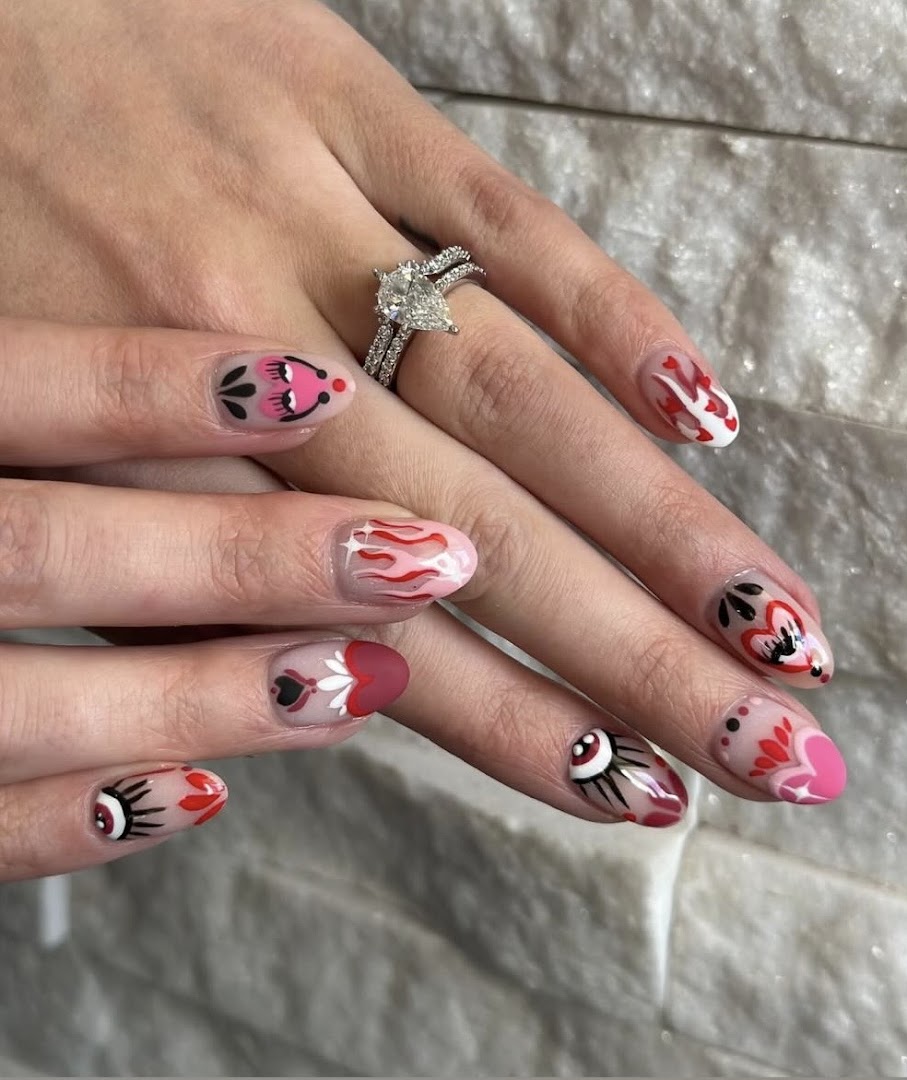 Detailed heart and flame nail art with soft pink base on short almond nails