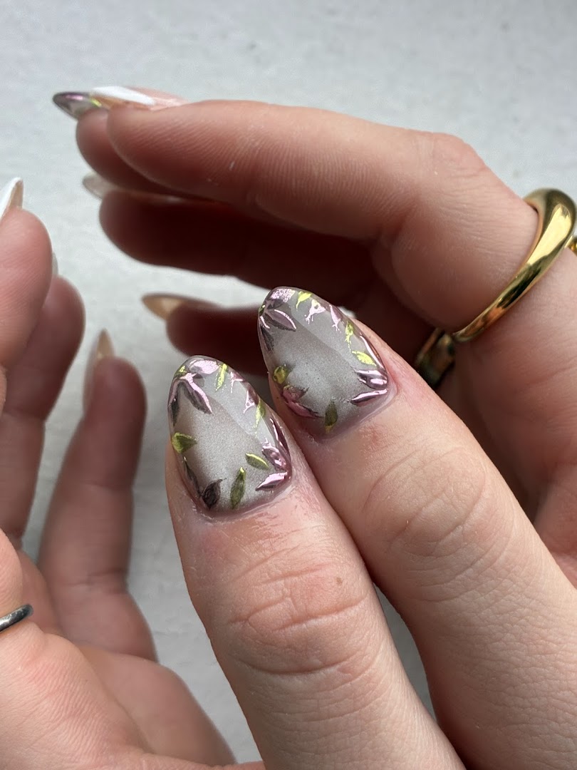 Delicate pink floral botanical nail art on short rounded nails with gold ring accent